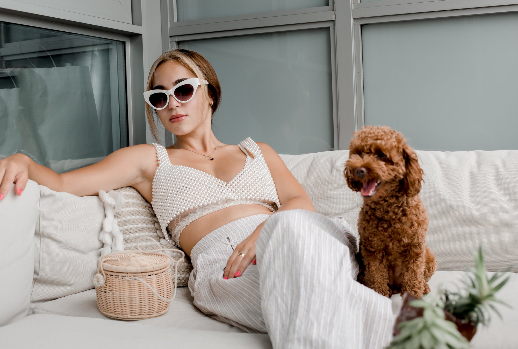 woman-leans-back-on-a-white-couch-with-a-small-puppy - Couchek